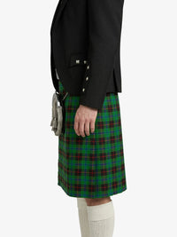 Person wearing a black jacket and green plaid kilt on a white background