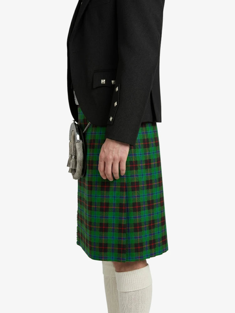 Person wearing a black jacket and green plaid kilt on a white background