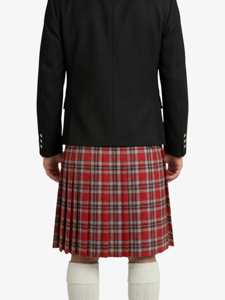 Person wearing a black jacket and red plaid kilt on a white background