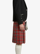 Person wearing a black blazer and red plaid kilt on a white background