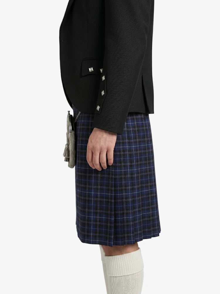 Person wearing a black jacket and blue plaid kilt on a white background