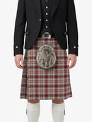 Person wearing a traditional Scottish kilt with a tartan pattern on a white background