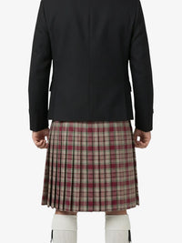 Person wearing a black jacket and plaid kilt on a white background