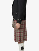 Person wearing a black jacket and plaid kilt on a white background