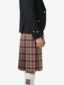 Person wearing a black jacket and plaid kilt on a white background
