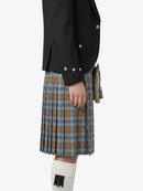 Person wearing a black jacket and plaid kilt on a white background