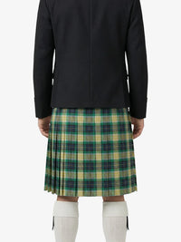 Person wearing a black jacket and green plaid kilt on a white background