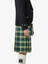 Person wearing a black jacket and green plaid kilt on a white background