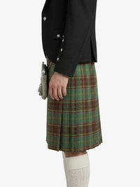 Person wearing a black jacket and plaid kilt on a white background