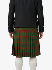 Person wearing a black coat and green plaid kilt on a white background