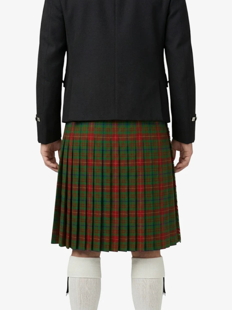 Person wearing a black coat and green plaid kilt on a white background