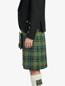 Person wearing a black jacket and green plaid kilt on a white background
