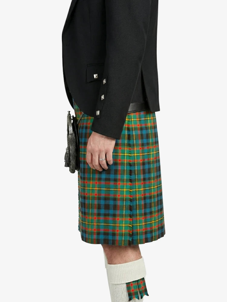Person wearing a black jacket and green plaid kilt on a white background