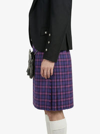 Person wearing a black jacket and purple plaid kilt on a white background