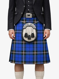 Person wearing a blue plaid kilt with a black jacket and white shirt on a white background