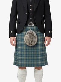 Person wearing a traditional Scottish kilt with a jacket on a white background