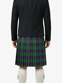 Person wearing a black jacket and green plaid kilt on a white background