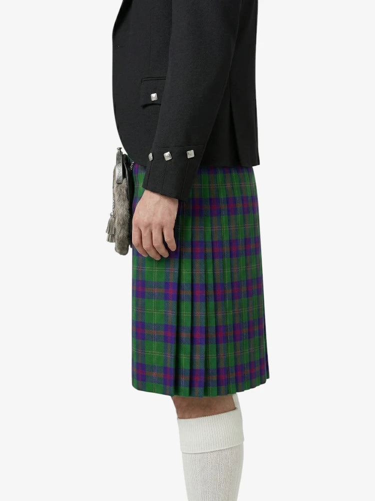 Person wearing a black jacket and green plaid kilt on a white background