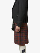 Person wearing a black jacket and red plaid kilt on a white background