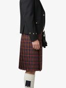 Person wearing a black jacket and red plaid kilt on a white background