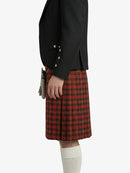 Person wearing a black jacket and red plaid kilt on a white background