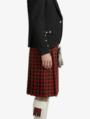 Person wearing a black jacket and red plaid kilt on a white background