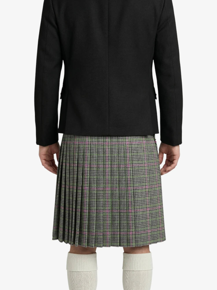 Person wearing a black jacket and plaid kilt on a white background