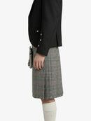 Person wearing a black jacket and plaid skirt on a white background