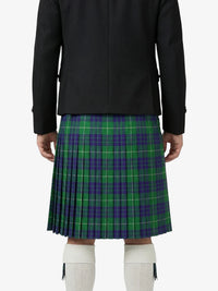 Person wearing a black jacket and green plaid kilt on a white background