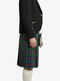 Person wearing a black blazer and plaid kilt on a white background