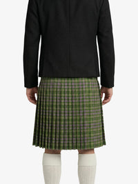 Person wearing a black jacket and green plaid kilt on a white background