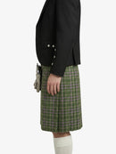 Person wearing a black blazer and green plaid kilt on a white background