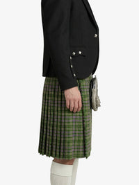 Person wearing a black blazer and green plaid kilt on a white background
