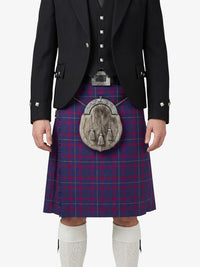 Person wearing a Scottish kilt with a tartan pattern on a white background