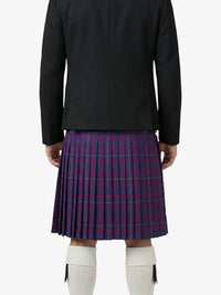 Person wearing a black jacket and red plaid kilt on a white background