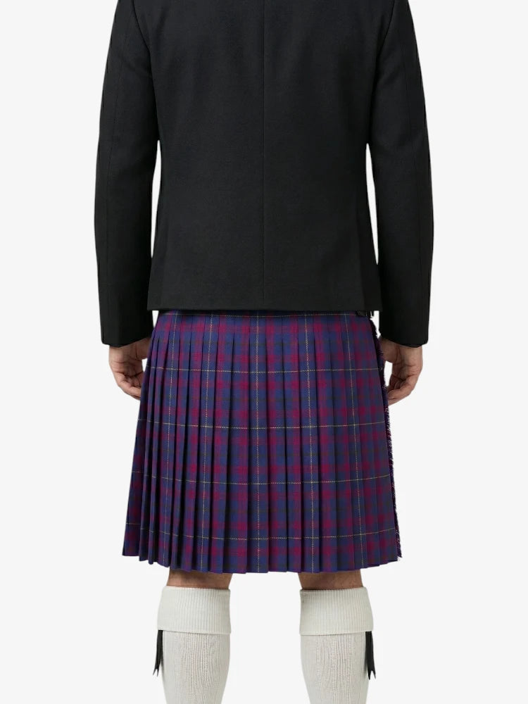 Person wearing a black jacket and red plaid kilt on a white background