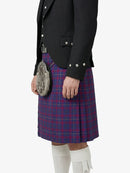Person wearing a traditional Scottish kilt with a jacket on a white background