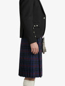 Person wearing a black blazer and plaid kilt on a white background