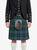 Person wearing a black jacket and green plaid kilt on a white background