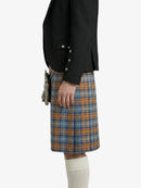 Person wearing a black blazer and plaid kilt on a white background