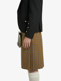 Person wearing a black jacket and plaid kilt on a white background