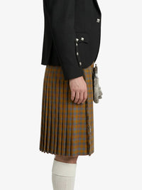 Person wearing a black jacket and plaid kilt on a white background