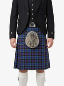 Person wearing a traditional Scottish kilt with a tartan pattern on a white background