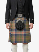 Person wearing a traditional Scottish kilt with a tartan pattern on a white background