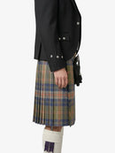 Person wearing a black jacket and plaid kilt on a white background