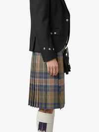 Person wearing a black jacket and plaid kilt on a white background
