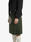 Person wearing a black jacket and green plaid kilt on a white background