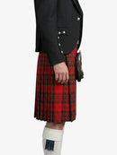 Person wearing a black jacket and red plaid kilt on a white background
