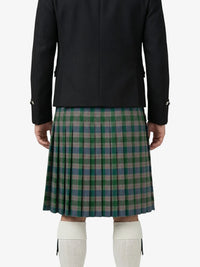 Person wearing a black jacket and green plaid kilt on a white background