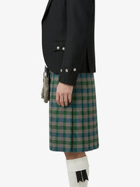 Person wearing a black jacket and green plaid kilt on a white background
